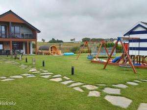 - une aire de jeux avec des toboggans et des balançoires dans la cour dans l'établissement Holiday Home in Mielno near Beach & Lake, à Mielenko