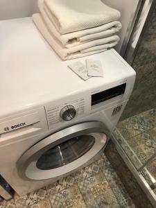 ウファにあるKEY апарт-отельの白い洗濯機(タオル付)