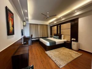 a hotel room with a bed and a tv at Yuhi Suites in Gurgaon