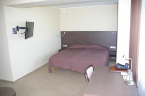 a small bedroom with a bed and a table at Tehvandi Hotell in Otepää