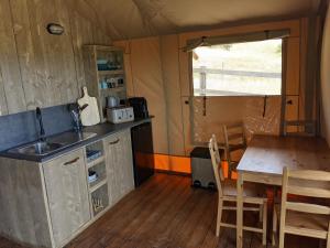 eine Küche und ein Esszimmer mit einem Tisch und einem Waschbecken in der Unterkunft Maple Park in Kilmore East
