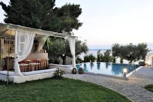 a backyard with a pool and a gazebo at Holiday residence Acrotel Athena Villas, Elia Beach in Kalogria