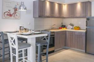 a kitchen with wooden cabinets and a counter with stools at Holiday residence Acrotel Athena Villas, Elia Beach in Kalogria