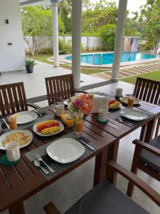 a wooden table with plates of food on it at Villa Riverside in Aluthgama