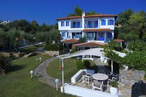 - une vue aérienne sur une maison avec une table et des chaises dans l'établissement Holiday residence Acrotel Athena Villas, Elia Beach, à Kalogria