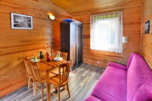 uma sala de jantar com uma mesa e um sofá roxo em Holiday home in Ustronie Morskie not far from the sea em Ustronie Morskie