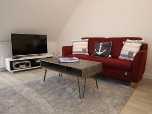 a living room with a red couch and a coffee table at Ferienwohnung in St Peter-Ording in Sankt Peter-Ording