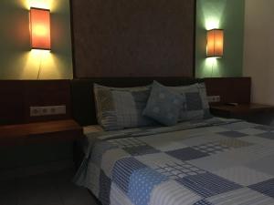 ein Schlafzimmer mit einem Bett mit zwei Leuchten in der Unterkunft Nadialit in Seminyak