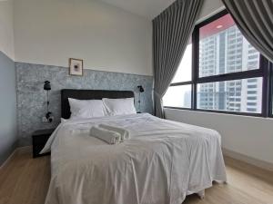 a bedroom with a white bed with two towels on it at LIV Signature Arte Plus in Kuala Lumpur