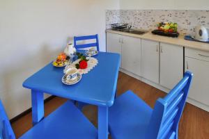 a blue table with a bowl of fruit and flowers on it at Holiday studio with terrace for 3 people Jaroslawiec in Jarosławiec
