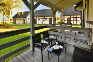 a deck with tables and chairs on a building at Holiday studio with terrace for 3 people Jaroslawiec in Jarosławiec