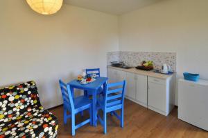 una pequeña cocina con una mesa y sillas azules y una encimera. en Holiday studio with terrace for 3 people Jaroslawiec, en Jarosławiec