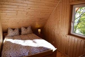 a bedroom with a bed in a wooden cabin at holiday home, Parchowo in Parchowo