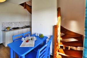 a dining room with a blue table and chairs at Holiday bungalow for 4 people Jaroslawiec in Jarosławiec