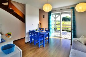 a living room with a blue dining room table with chairs at Holiday bungalow for 4 people Jaroslawiec in Jarosławiec