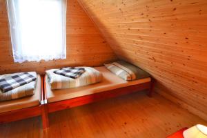 two beds in a log cabin with a window at Holiday home in Ustronie Morskie with a playground in Ustronie Morskie
