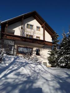 un edificio con un cartello sopra nella neve di Pension Waldeck Fleckl a Warmensteinach