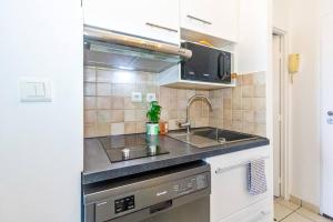 uma cozinha com um lavatório e um fogão em Océanides - studio rénové avec magnifique vue mer - Saint-Gilles-Les-Bains em Saint-Gilles-les Bains