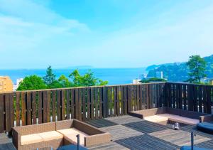 熱海市にあるATAMI SPRING TERRACE HOTELのパティオ(テーブル、フェンス上のベンチ付)