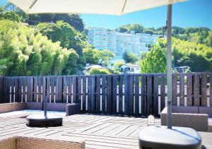 a patio with two benches and an umbrella at ATAMI SPRING TERRACE HOTEL in Atami