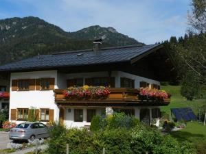 a house with flower boxes on the front of it at Gästehaus Glaagut - Familie Hain in Hochfilzen