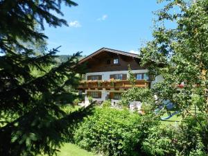 ein Gebäude inmitten einiger Bäume in der Unterkunft Gästehaus Glaagut - Familie Hain in Hochfilzen