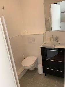 ein weißes Bad mit einem WC und einem Waschbecken in der Unterkunft Appartement vue mer in La Baule