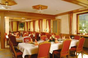 un comedor con mesas y sillas en un restaurante en Gasthof Krone, en Schuttertal