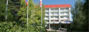 a hotel with two flags in front of a building at Tavria Hotel in Simferopol