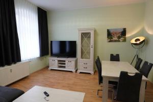 a living room with a tv and a table with chairs at Otto der Reiche in Ballenstedt
