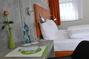 um quarto de hotel com uma cama e uma mesa com um candeeiro em SleepySleepy Hotel Gießen em Giessen