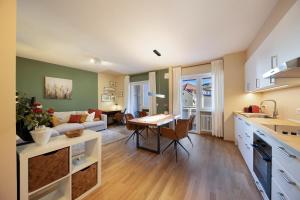 cocina y sala de estar con sofá y mesa en Apartment Huita en Bolzano