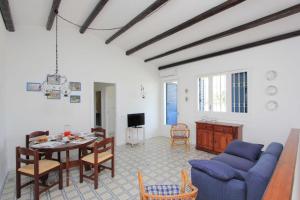 un soggiorno con un tavolo e un divano blu di Sud Est Le Case di Elisa a Marina di Ragusa