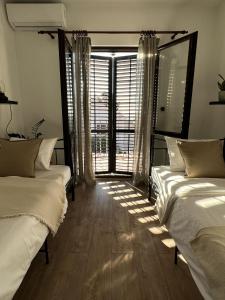 a bedroom with two beds and a large window at Villa Gem in Mravince