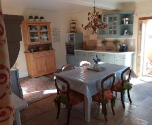 a kitchen with a table and chairs in a room at Ancien Domain "Le petit Bonheur" in Tailly