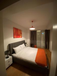 ein Schlafzimmer mit einem großen Bett mit einer orangefarbenen Decke in der Unterkunft The Y Istanbul Suites in Istanbul + 37 Fotos