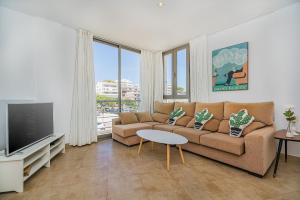 Una sala de estar con un sofá y un televisor. en Molins 5, en Cala de Sant Vicent
