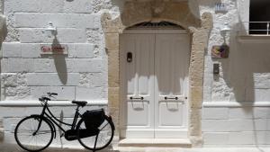 una bicicletta parcheggiata di fronte a un edificio con porta di Affittacamere La Cattedrale a Monopoli