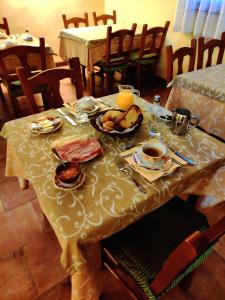 una mesa con un mantel amarillo con comida. en Hotel Albarrán en Albarracín