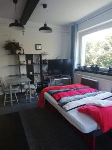 a bedroom with a bed and a table and a window at Apartament Pod Kukułką in Kłodzko