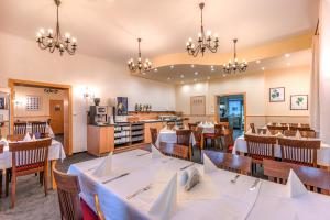 ein Esszimmer mit Tischen und Stühlen in einem Restaurant in der Unterkunft Wellness Hotel IRIS in Pavlov