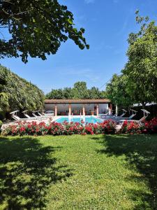 a swimming pool with flowers in a yard at Agriturismo Corte Spino in Nogarole Rocca