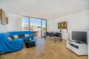 sala de estar con sofá azul y TV en MOLINS 2, en Cala de Sant Vicent