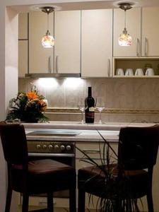 a kitchen with a counter with two chairs and a bottle of wine at Apartments Twins in Herceg-Novi