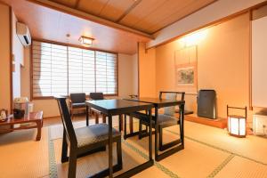 a dining room with a table and chairs at Ryokan Tamura in Kusatsu