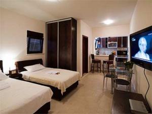 a hotel room with two beds and a flat screen tv at Apartments Twins in Herceg-Novi