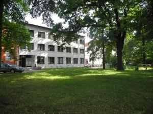 - un grand bâtiment blanc avec un arbre dans la cour dans l'établissement Hotel Kristl, à Pardubice