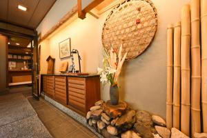 a room with a vase on a wall at Ryokan Tamura in Kusatsu