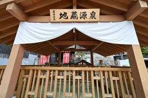 a restaurant with a sign on top of a wooden fence at Ryokan Tamura in Kusatsu