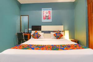 FabHotel Maxx Inn في نيودلهي: غرفة نوم بسرير كبير بجدران زرقاء